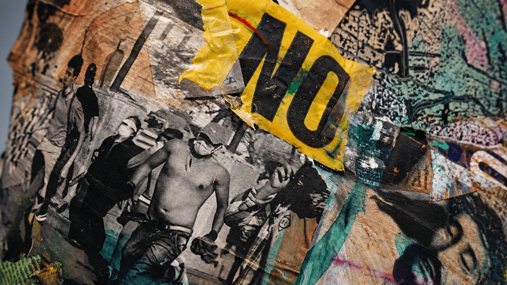 Collage urbano con nastro giallo “NO”